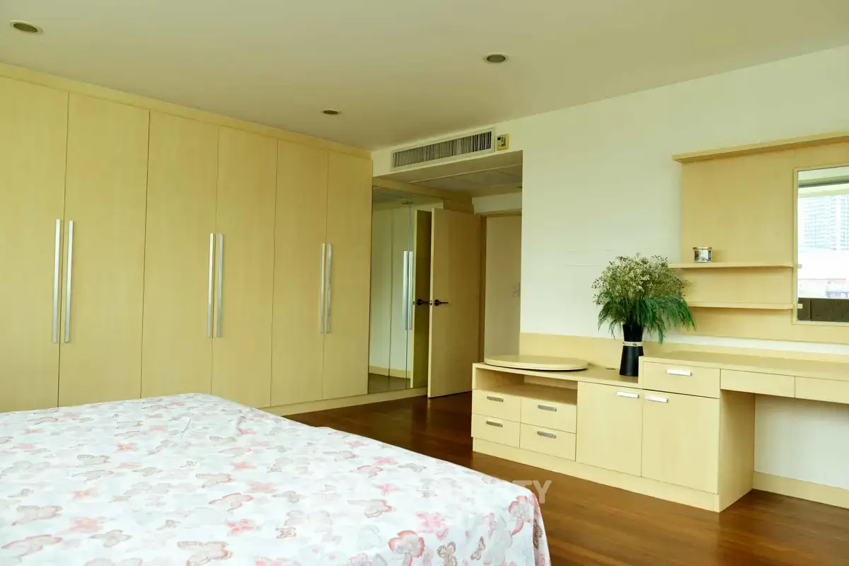 Spacious bedroom with built-in wardrobes and elegant wooden flooring