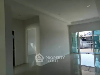 Spacious modern living room with large windows and glossy tiled floors