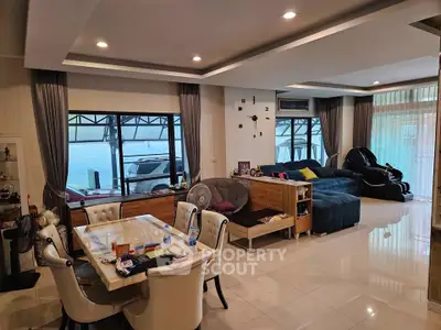 Spacious living room with modern decor and ample natural light, perfect for family gatherings.