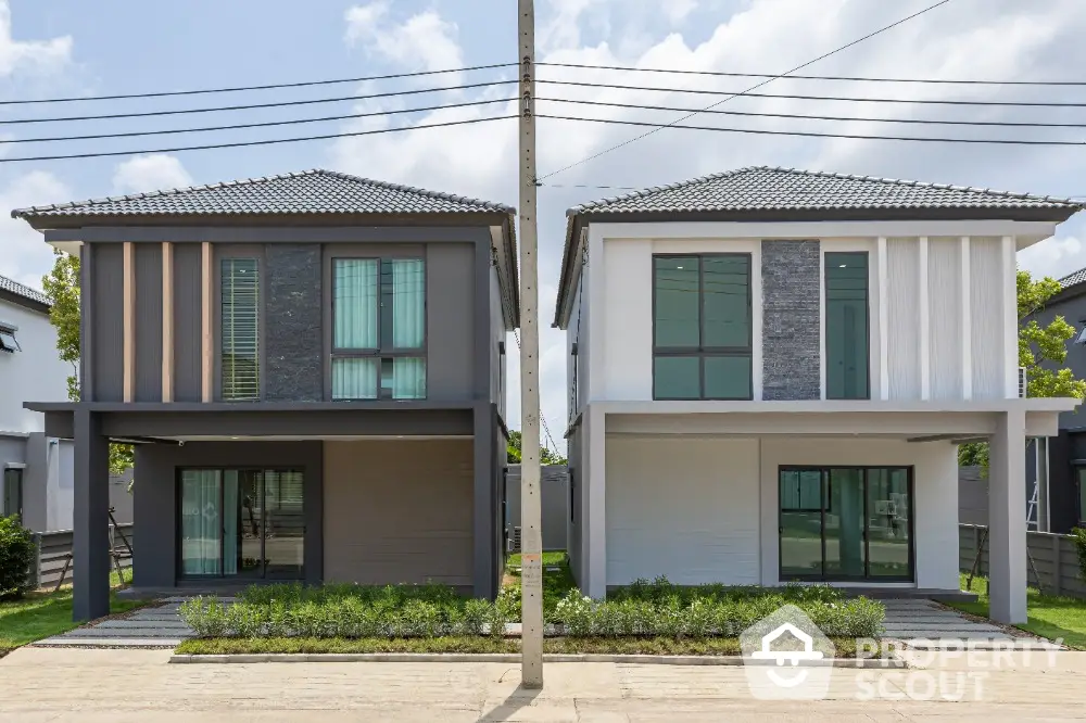 Modern two-story duplex homes with stylish facades and landscaped front yards.