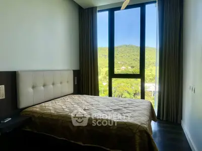Spacious bedroom with large window offering stunning mountain views, perfect for relaxation and tranquility.