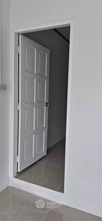 Minimalist white interior door in modern apartment hallway
