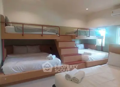 Spacious bedroom with multiple beds and modern design, perfect for family or group stays.