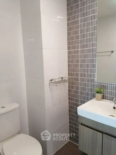 Modern bathroom with sleek tiles and compact sink design