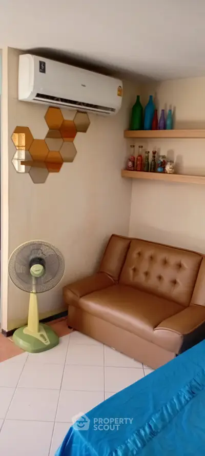 Cozy living room with modern decor and air conditioning, perfect for relaxation.