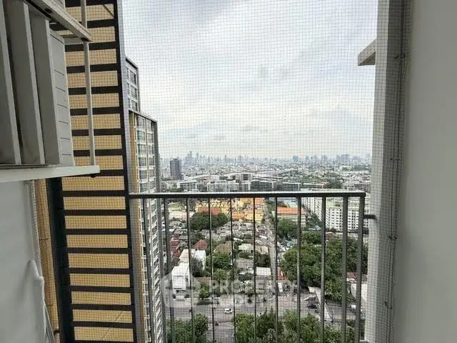 Stunning cityscape view from high-rise balcony with safety netting.