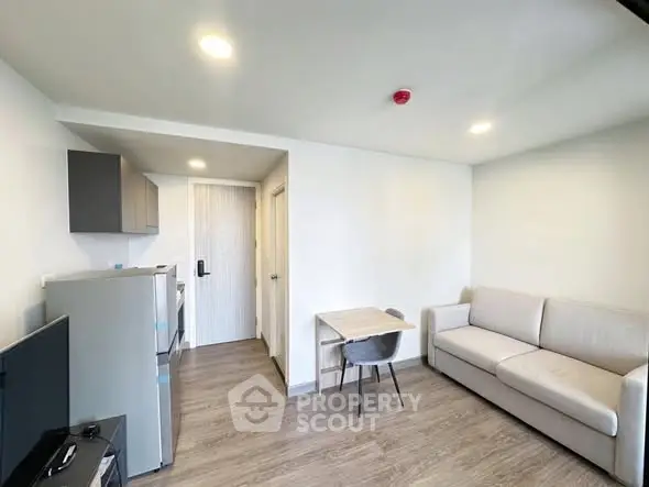 Modern living room with cozy sofa and compact kitchen area