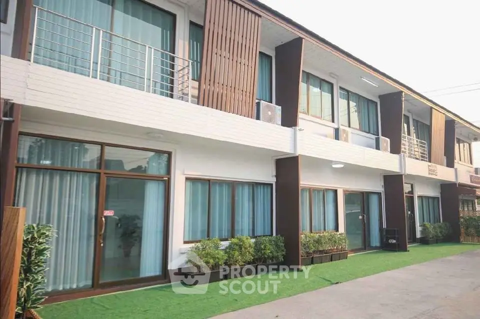 Modern townhouse exterior with green landscaping and large windows