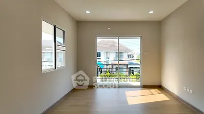Bright empty room with large windows and balcony access, perfect for customization.