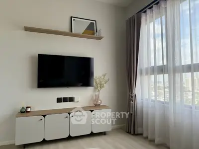 Modern living room with wall-mounted TV, stylish cabinet, and large window with city view.