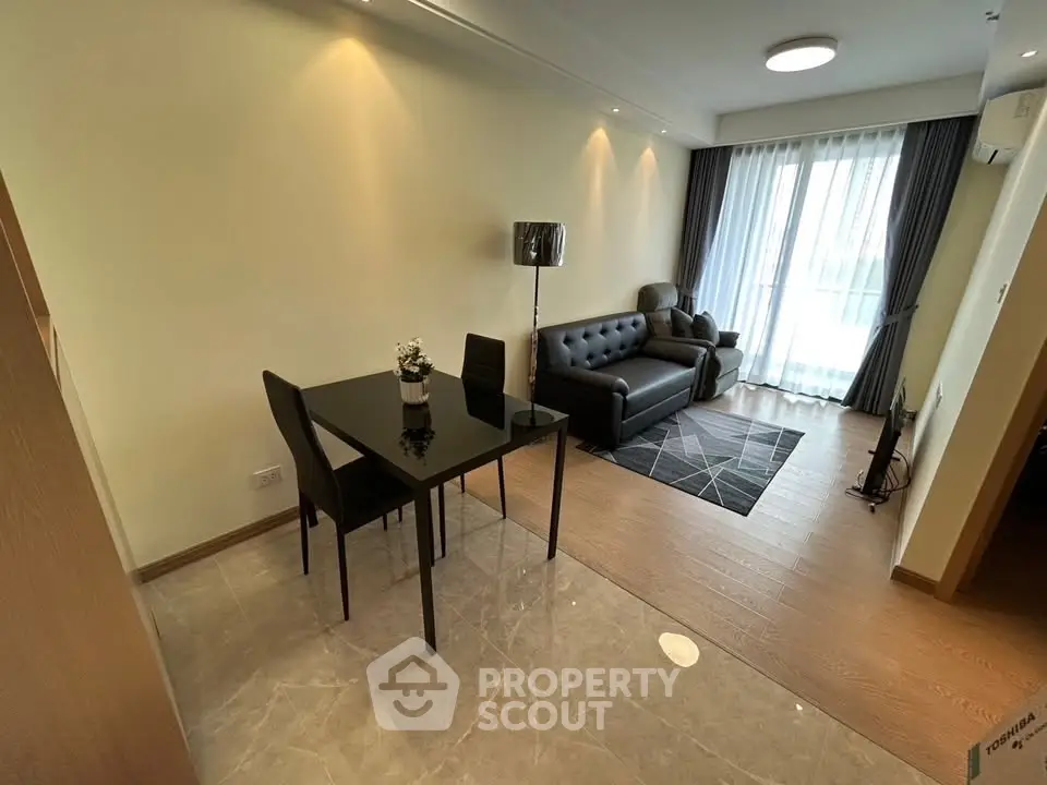 Modern living room with elegant dining area and natural light, featuring stylish furniture and wooden flooring.