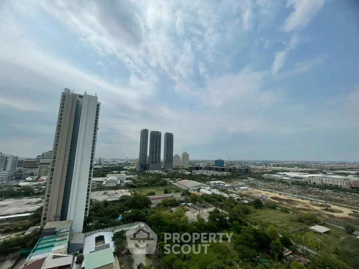 Stunning cityscape view from high-rise building showcasing urban skyline and lush greenery.
