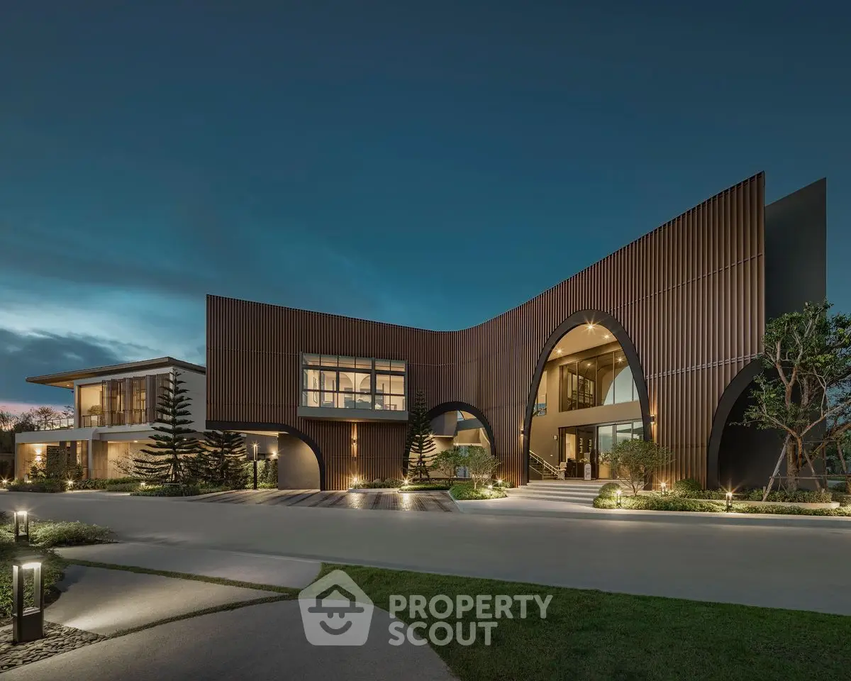 Stunning modern architectural masterpiece with unique curved facade and elegant lighting at dusk.