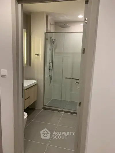 Modern bathroom with glass shower enclosure and sleek fixtures