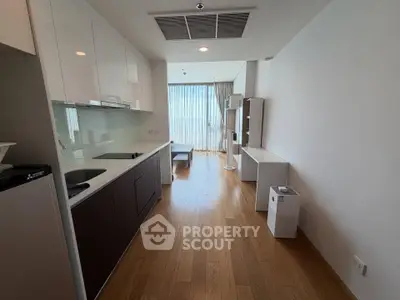 Modern apartment interior with sleek kitchen and spacious living area, featuring floor-to-ceiling windows.