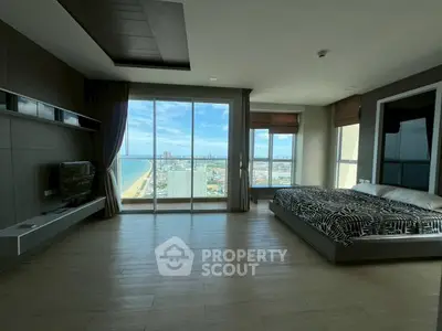 Spacious bedroom with stunning ocean view and modern decor in high-rise apartment.