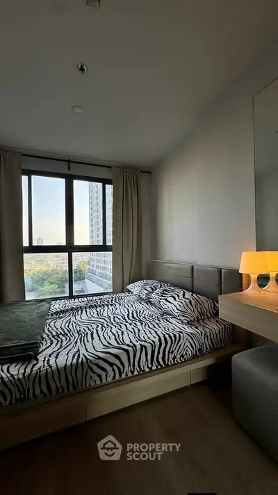 Modern bedroom with large window and stylish decor in high-rise apartment