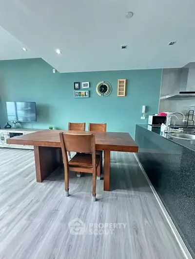 Modern open-layout kitchen and dining area with sleek design and wooden furniture.