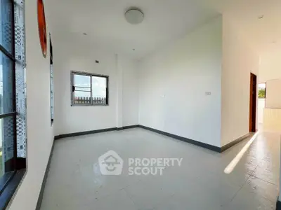 Spacious empty room with large windows and bright natural light