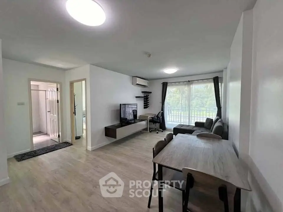 Modern living room with dining area and large window in a bright apartment