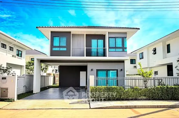 Modern two-story house with sleek design and spacious driveway in a suburban neighborhood.