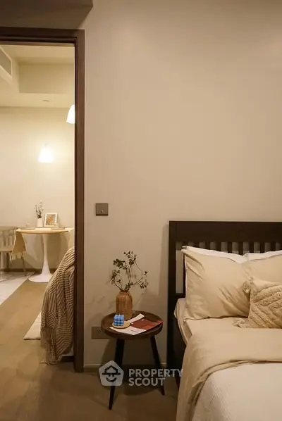 Cozy bedroom with warm lighting and modern decor, featuring a comfortable bed and stylish side table.