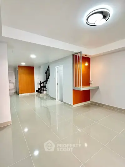 Modern open-plan living area with sleek staircase and stylish lighting