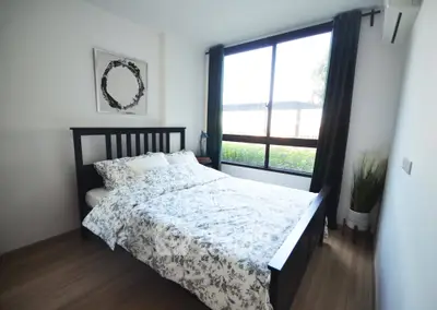 Cozy bedroom with large window and stylish decor in modern apartment