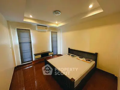 Spacious bedroom with modern design and ample natural light, featuring a comfortable bed and sleek flooring.