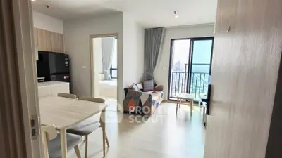 Modern open-plan living room with dining area and balcony view in a stylish apartment.