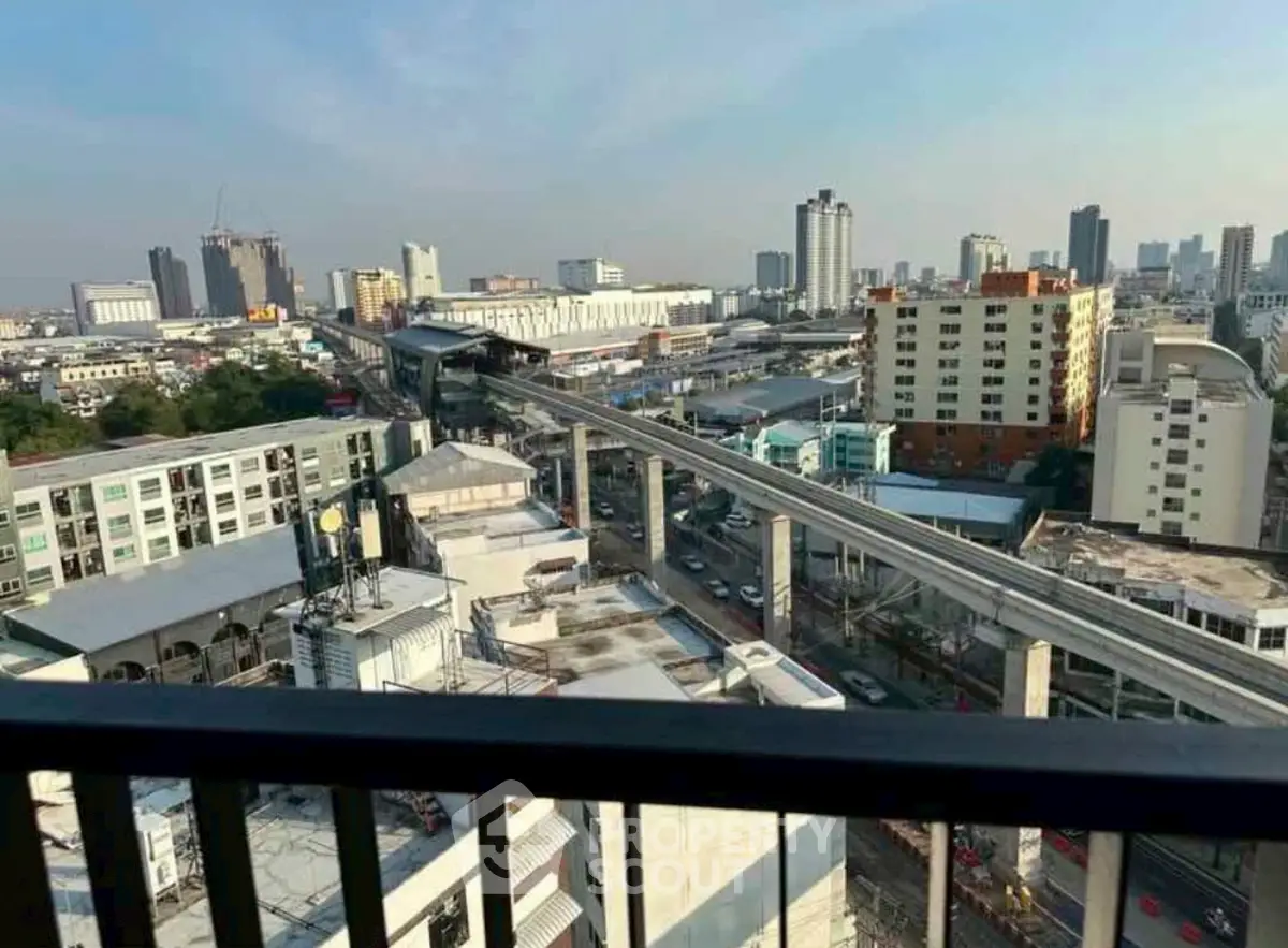 Stunning cityscape view from high-rise balcony overlooking urban skyline and transit lines.