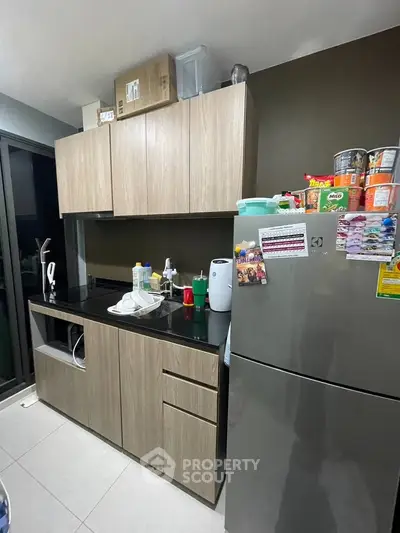 Modern kitchen with sleek cabinets and stainless steel fridge in a stylish apartment.