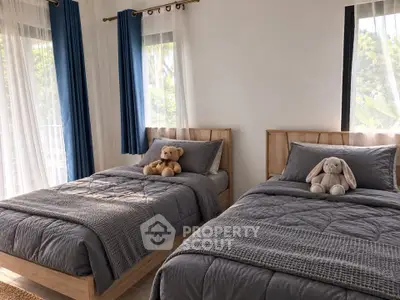 Charming twin bedroom with plush bedding and natural light