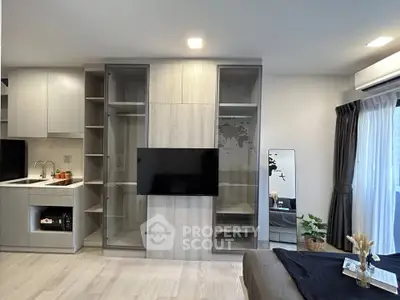 Modern living room with sleek built-in storage and TV, featuring a cozy ambiance and natural light.