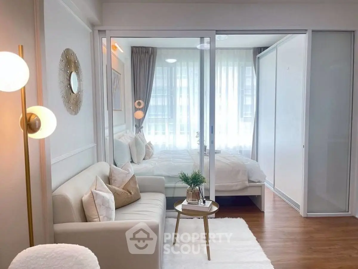 Chic modern living room with glass partition to cozy bedroom, elegant decor and natural light.