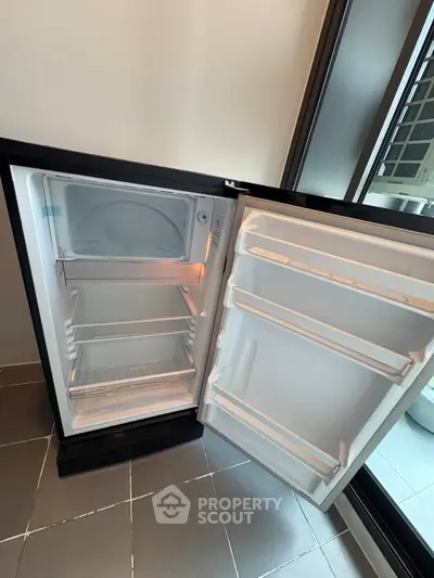 Modern kitchen with sleek open fridge showcasing ample storage space.