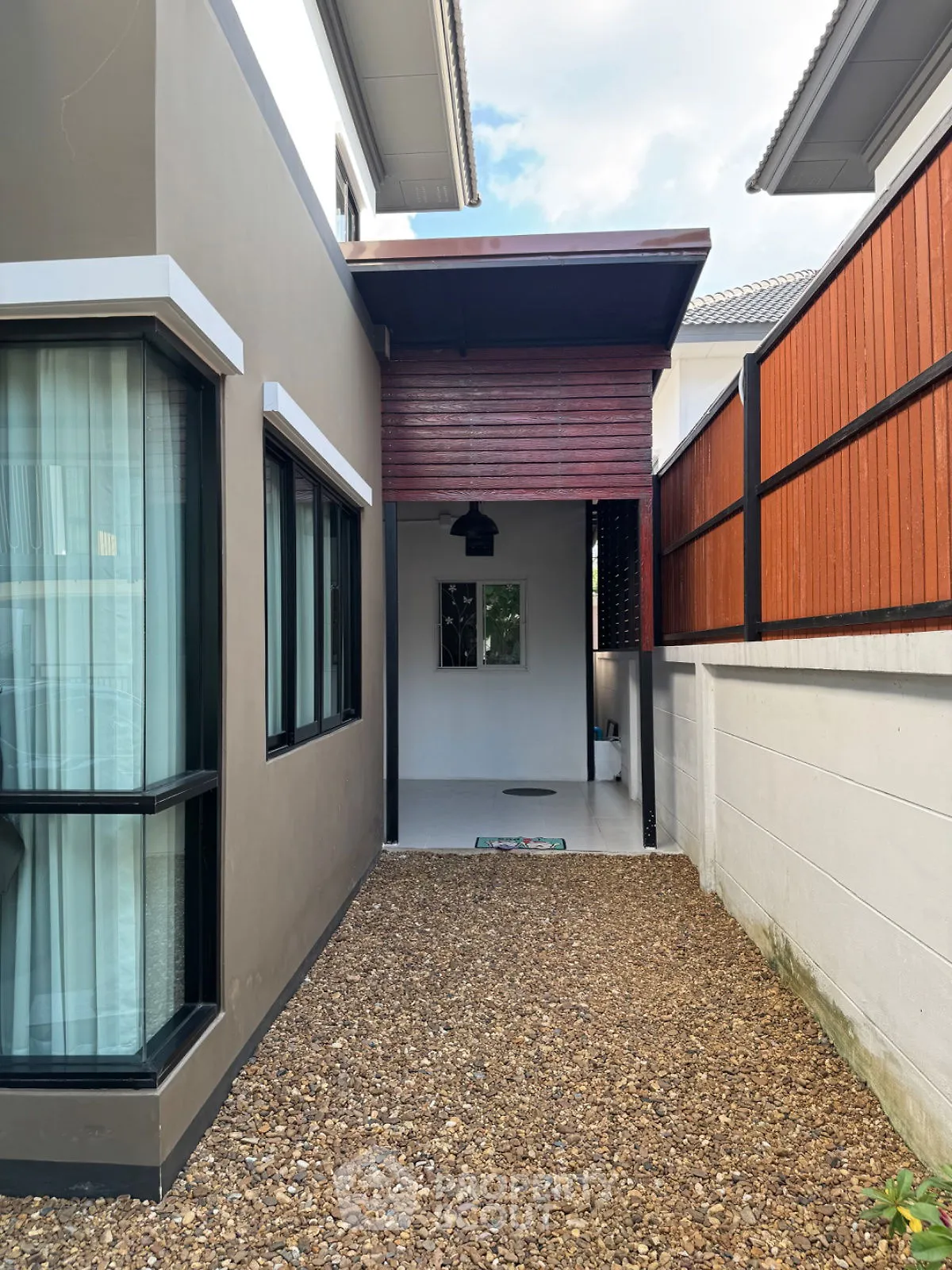 Charming modern house exterior with sleek design and gravel pathway, perfect for contemporary living.