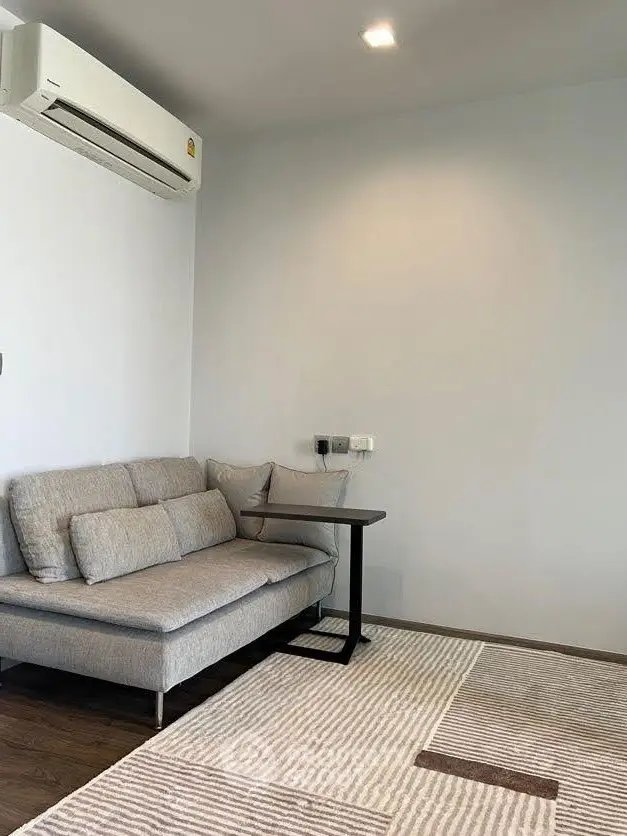 Modern living room with sleek sofa and air conditioning, perfect for cozy relaxation.