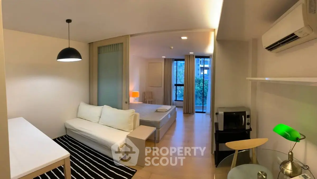 Modern studio apartment with open layout, featuring a cozy living area and bedroom, ideal for urban living.
