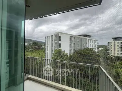 Spacious balcony with scenic view of modern apartment buildings and lush greenery.