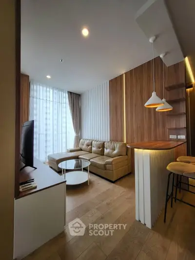 Modern living room with stylish decor and open layout, featuring a cozy leather sofa and elegant lighting.