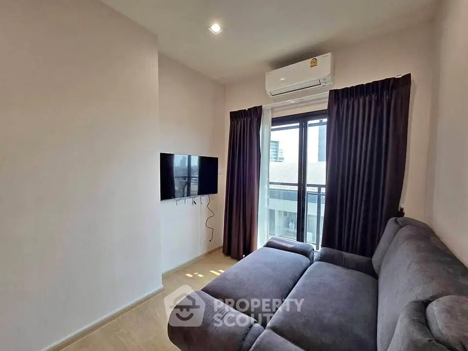 Cozy living room with modern sofa and wall-mounted TV, featuring a large window with city view.