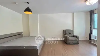 Spacious bedroom with modern lighting and large window for natural light.