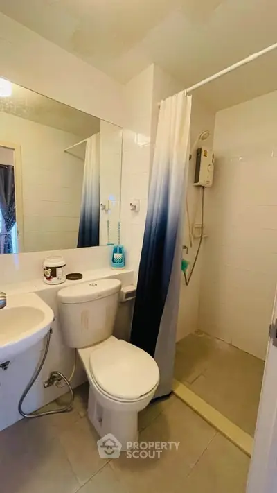 Compact bathroom with shower, toilet, and sink in modern apartment