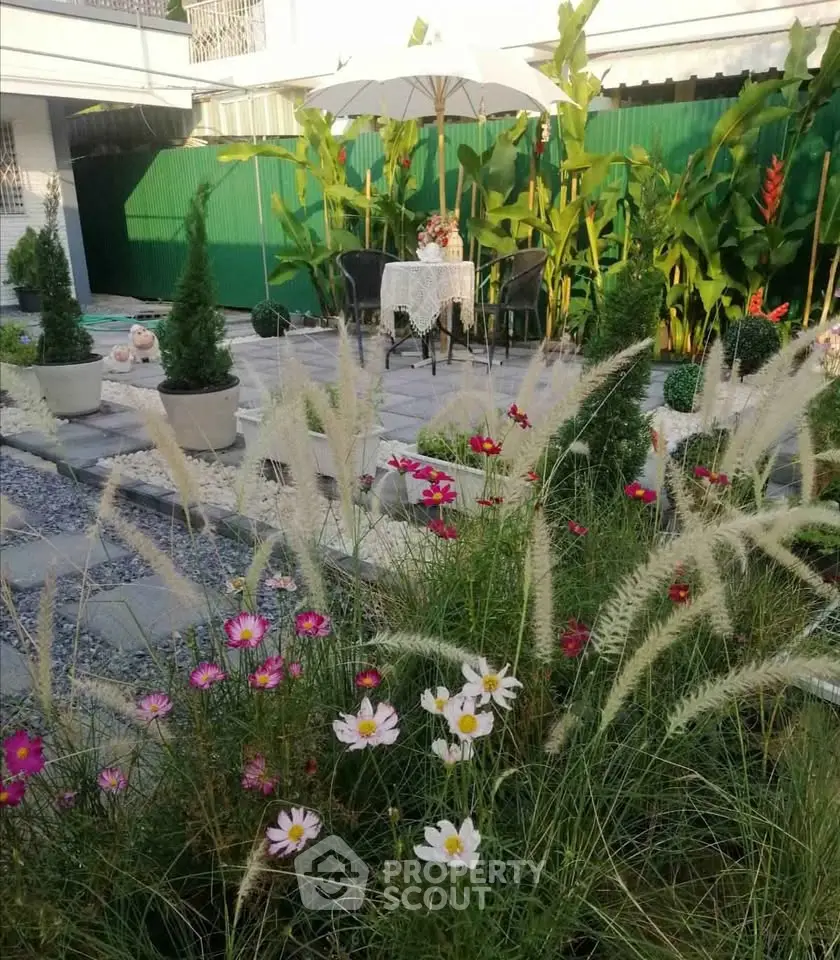 Charming garden with vibrant flowers and cozy seating area, perfect for outdoor relaxation and entertaining.