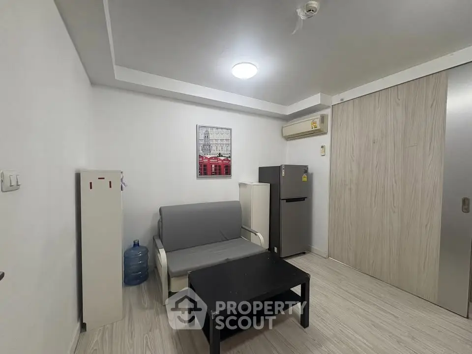 Modern living room with minimalist decor and compact furniture in a cozy apartment.