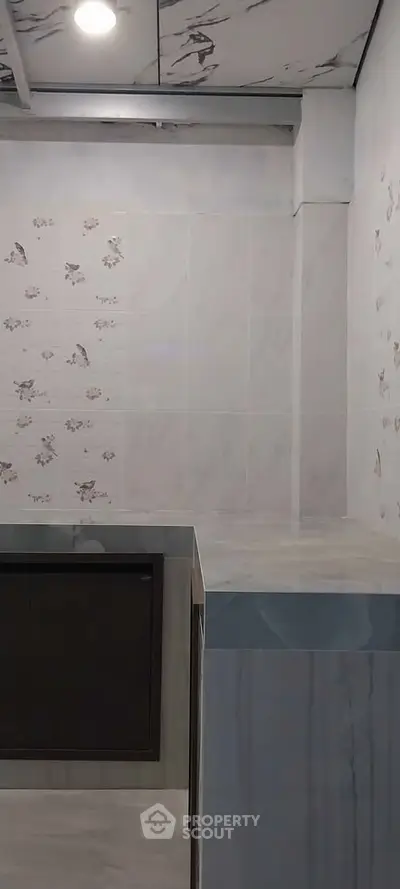 Modern kitchen with sleek marble countertops and floral tile accents