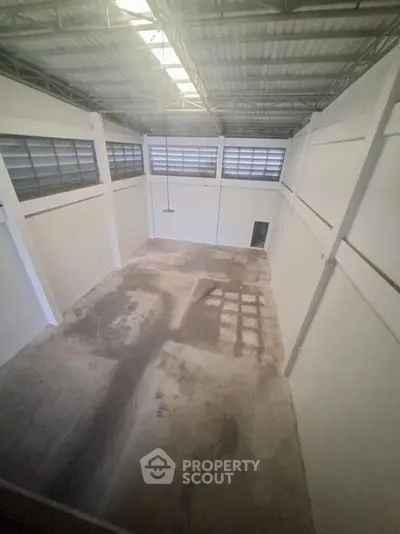 Spacious industrial warehouse with high ceilings and ample natural light.