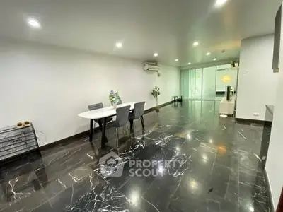 Spacious modern living room with sleek marble flooring and elegant dining area.