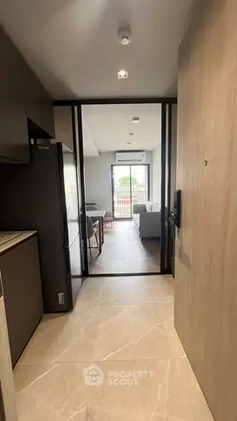 Modern apartment entrance leading to a bright living room with balcony view.